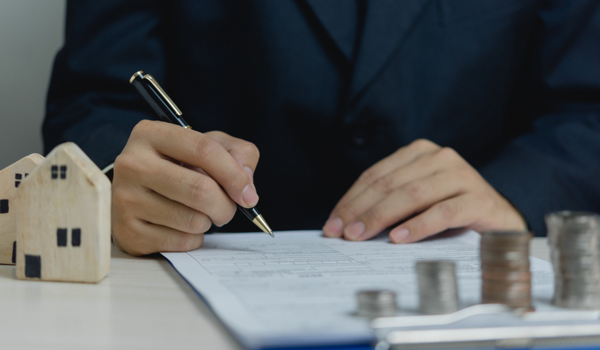 a person in a suit holding a pen and writing on a piece of paper